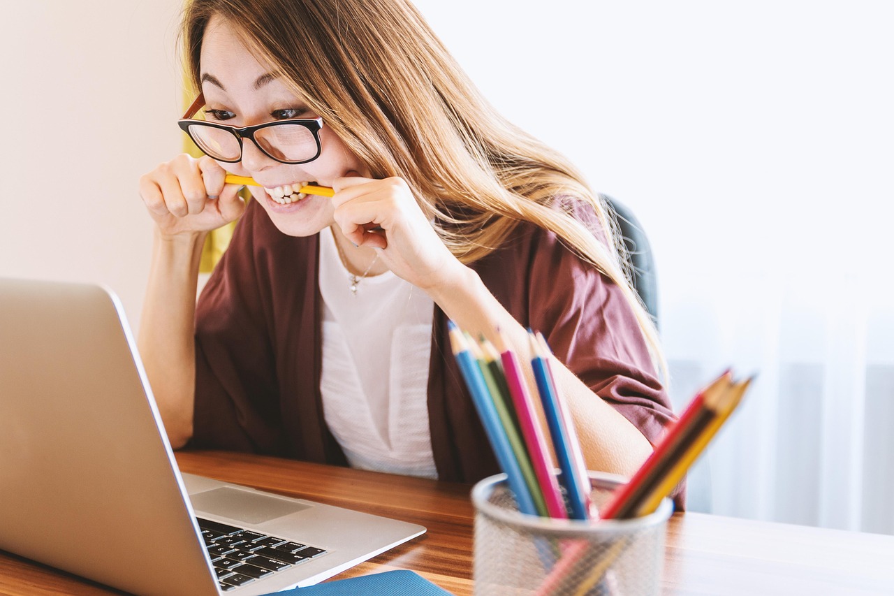 Desk setup with financial notes, laptop, and reading glasses for college savings planning