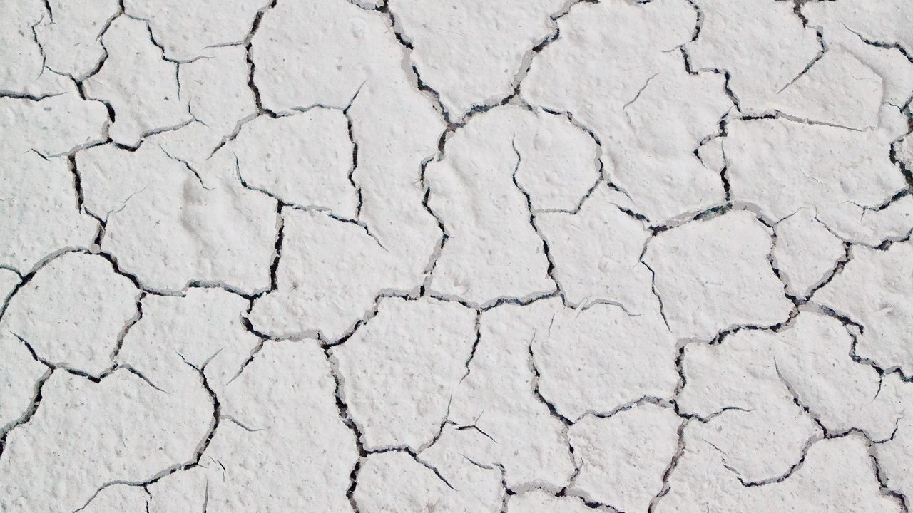 Close-up of a hairline crack on the surface of a white acrylic bathtub