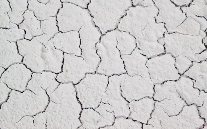 Close-up of a hairline crack on the surface of a white acrylic bathtub