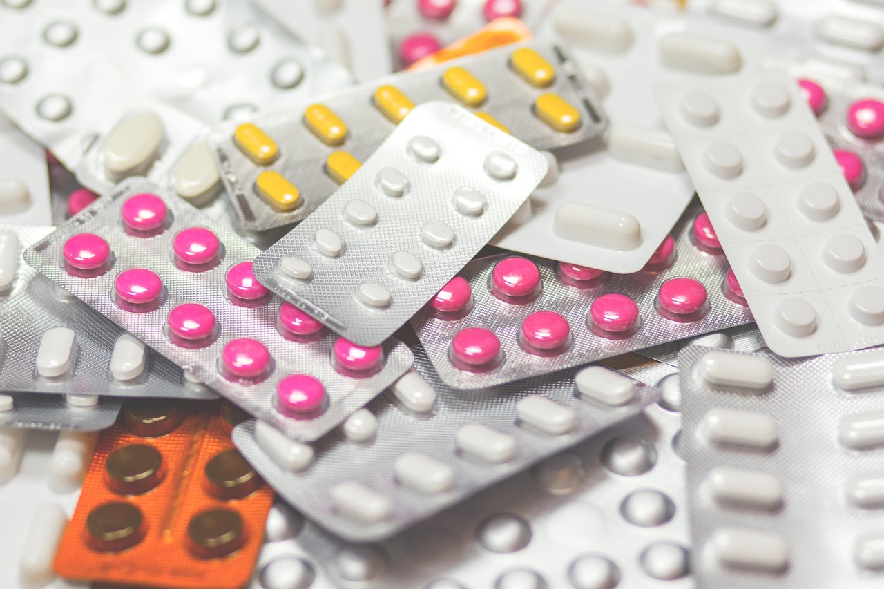 Medicare card placed near prescription medication bottles and notes on a desk.
