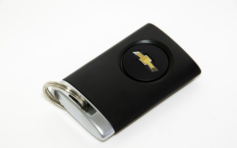 Modern automotive smart key fobs and a diagnostic scanning tool arranged on a workbench.