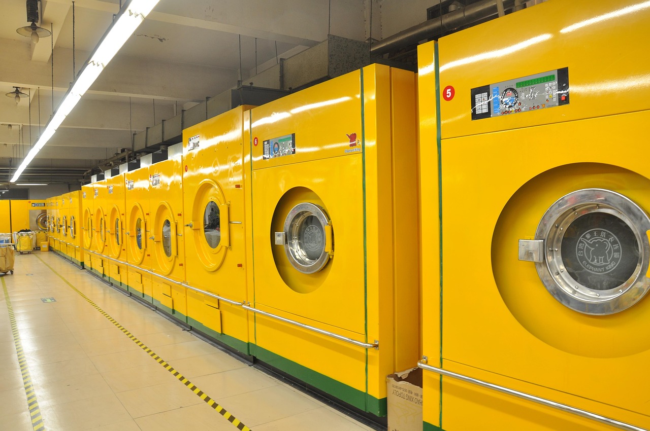 Homeowner loading clothes into a top-load washing machine