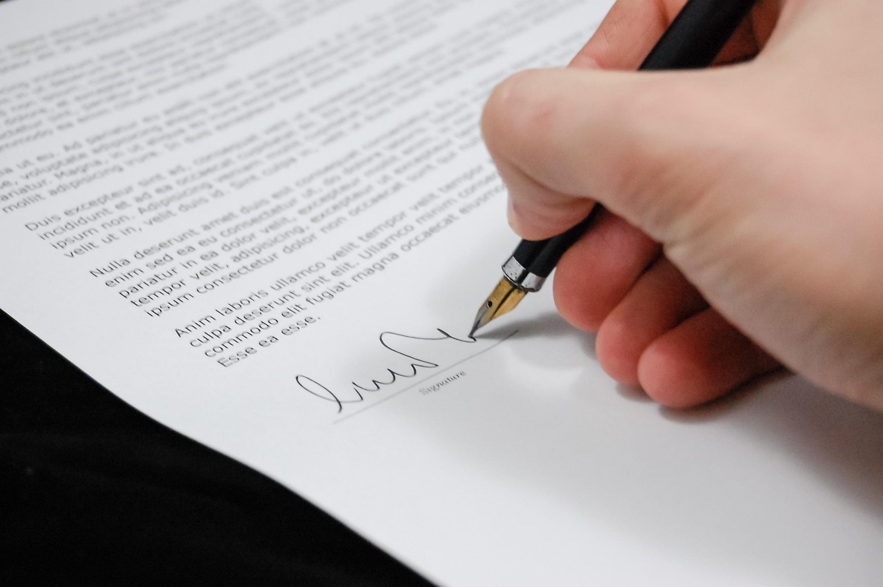 A printed lease agreement on a wooden desk with highlighters and a tablet document checklist.