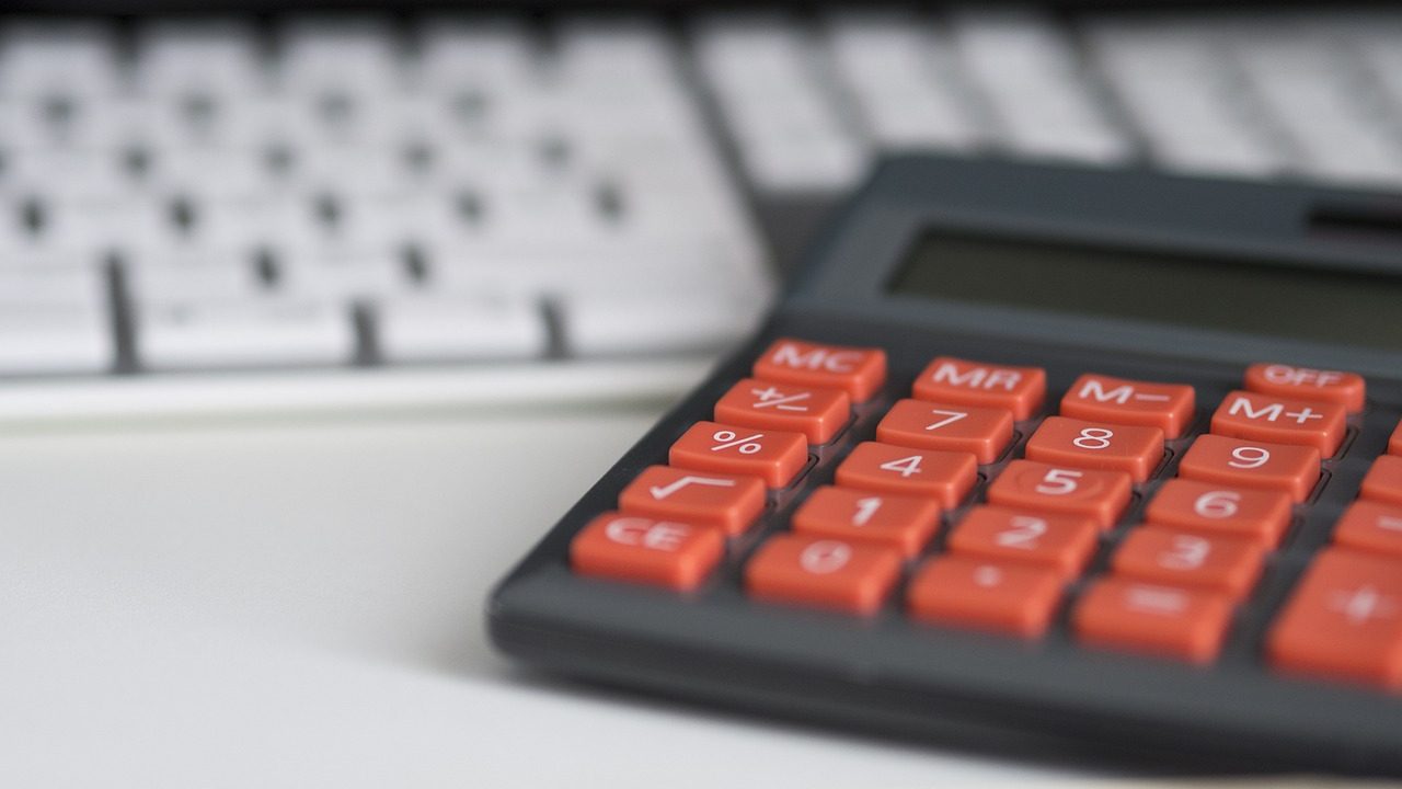 An emergency medical bill resting on a desk with a calculator and pen nearby.