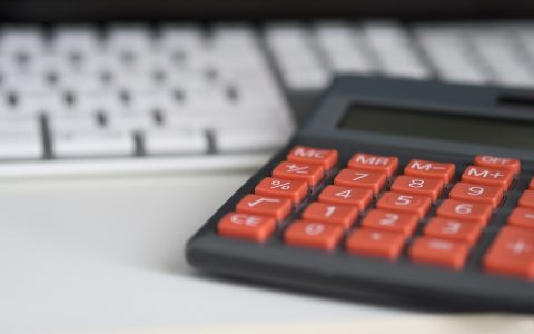 An emergency medical bill resting on a desk with a calculator and pen nearby.
