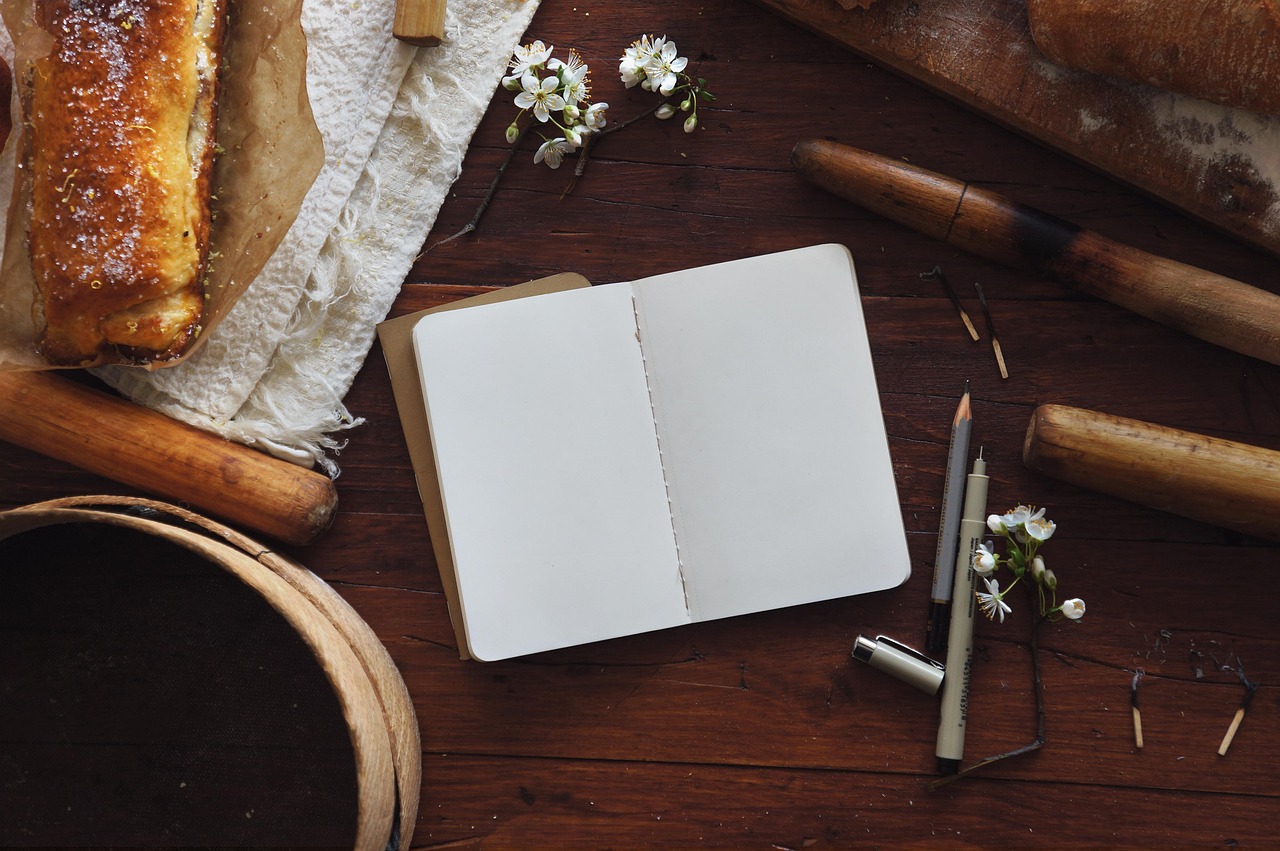 Organized electric utility bills, a notebook with calculations, and a pen on a wooden table.