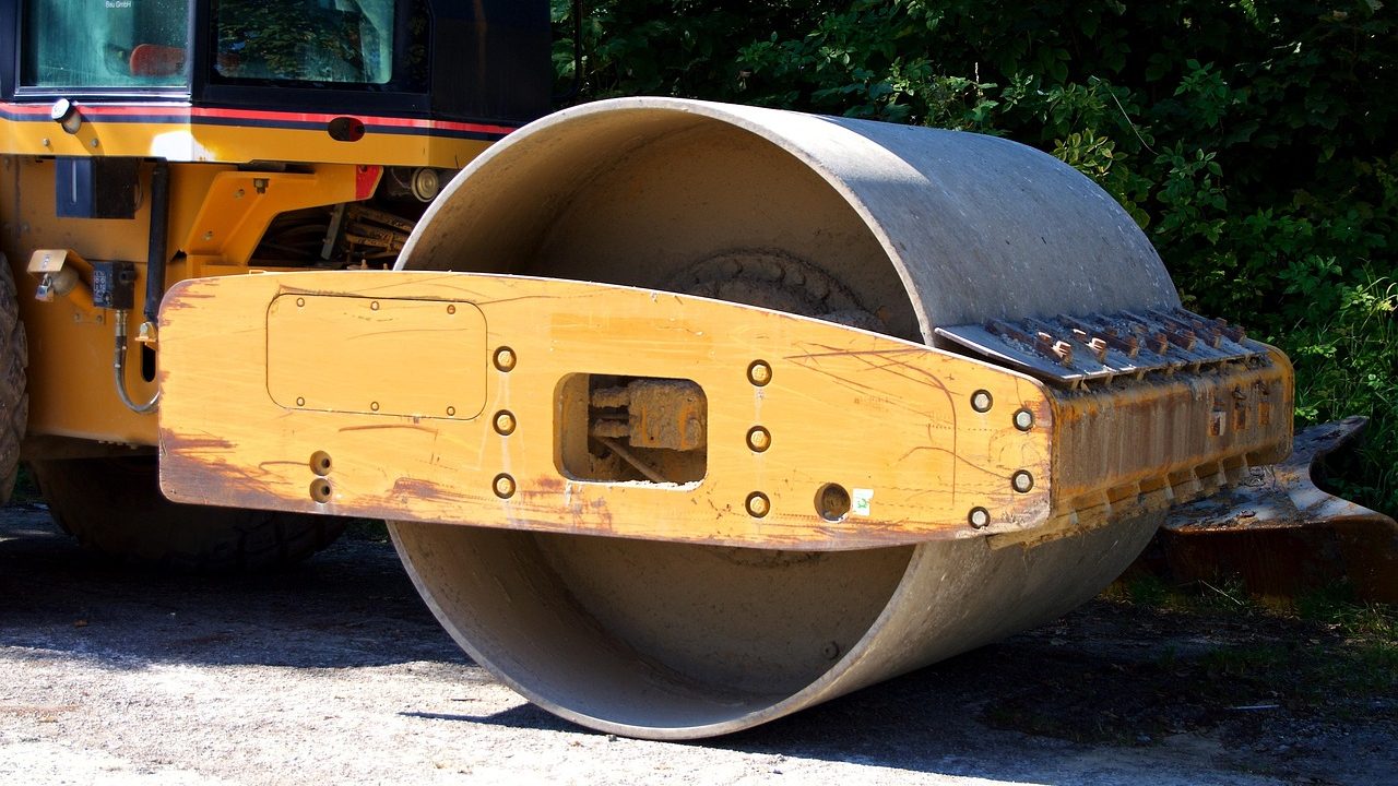 Heavy machinery laying new asphalt on a residential driveway