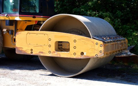 Heavy machinery laying new asphalt on a residential driveway
