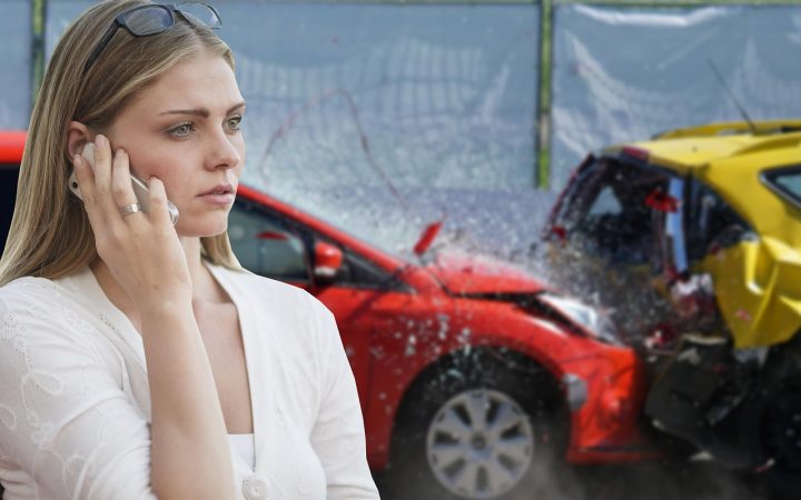 An insurance adjuster examining a damaged vehicle in an outdoor tow lot.