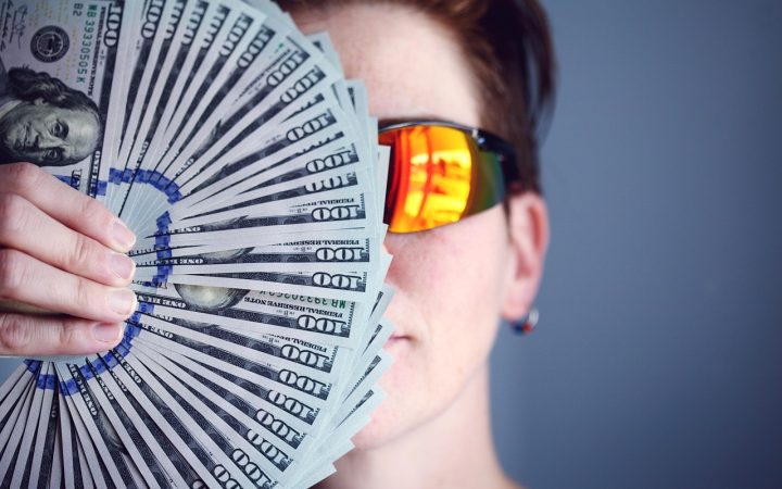 An investor quietly reviewing paper financial records at a sunny home office desk.