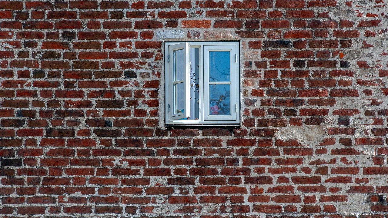 Insulation contractor retrofitting exterior house wall cavity with blown-in insulation