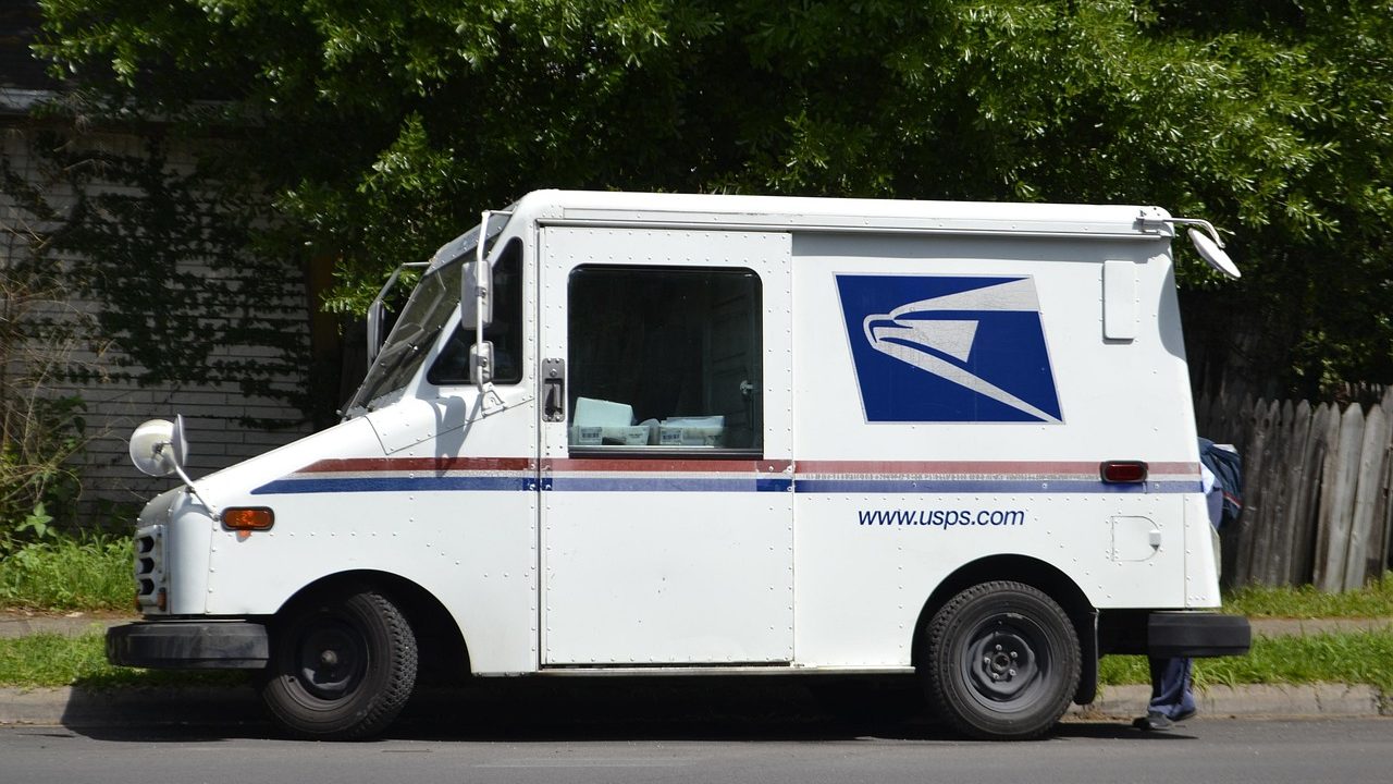 A retired postal delivery vehicle parked on a residential street.