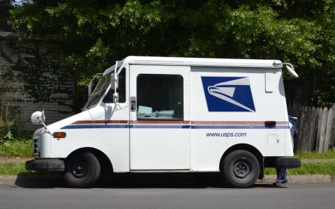 A retired postal delivery vehicle parked on a residential street.