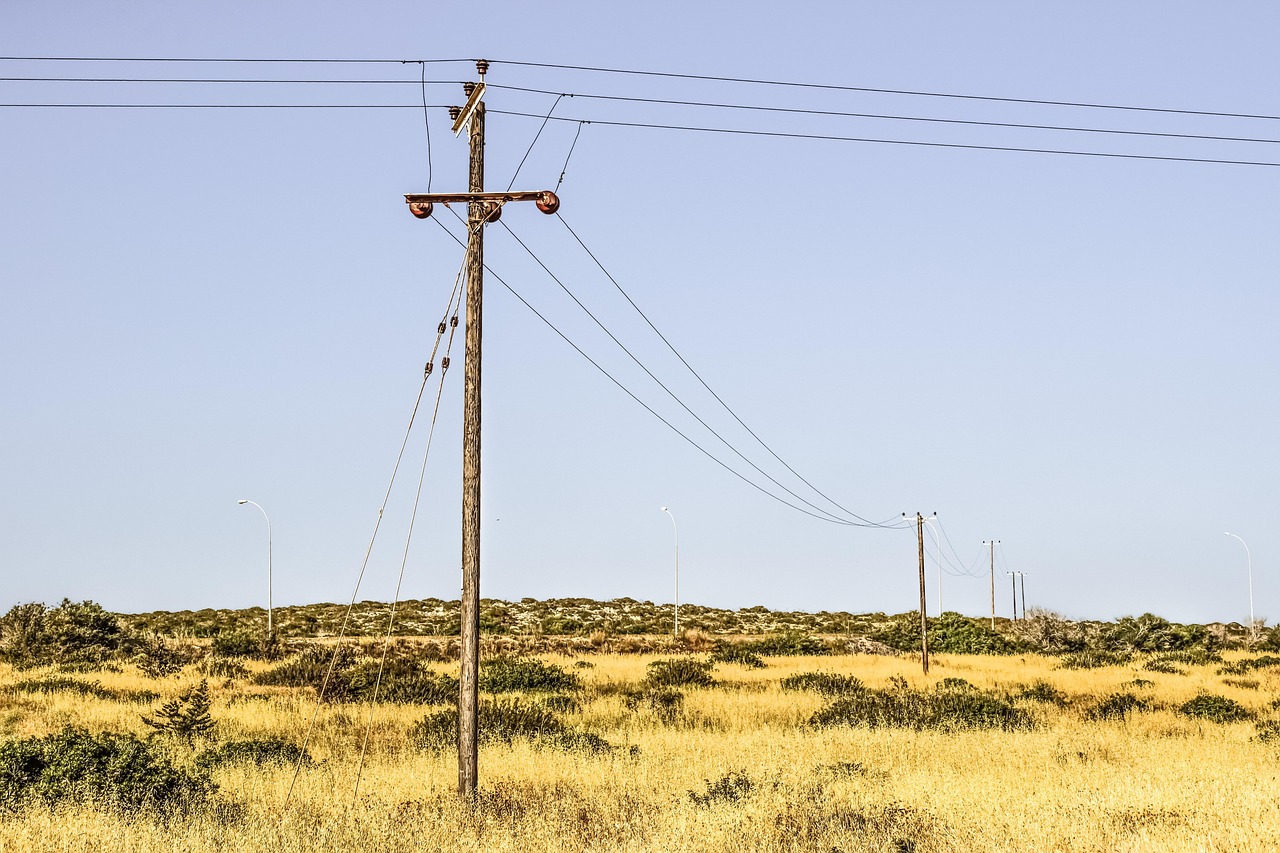 Telecommunication cables and utility wires mounted along suburban street poles.