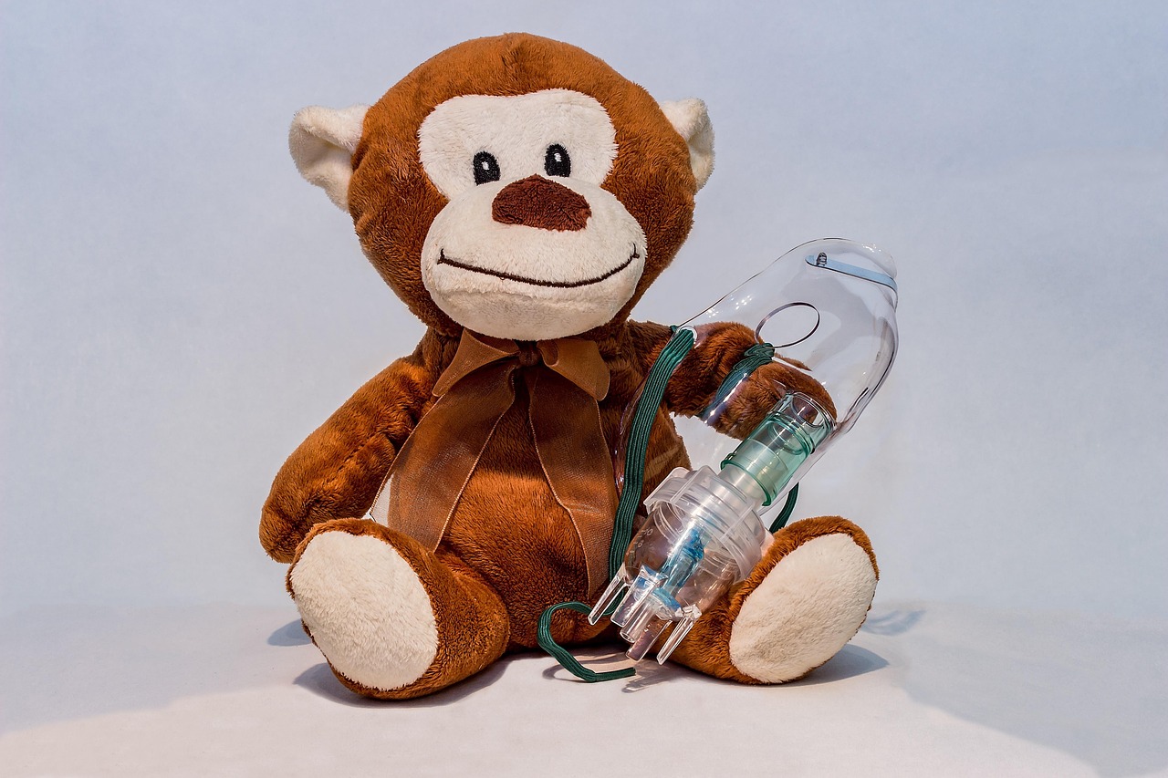 Handheld veterinary nebulizer mask and daily respiratory tracking log on a wooden tray.