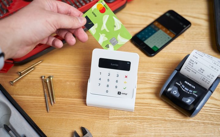 A consumer making a card payment at a modern retail checkout terminal.
