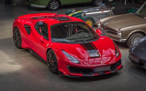 A clean car dealership showroom with a vehicle and a purchase agreement on a desk.