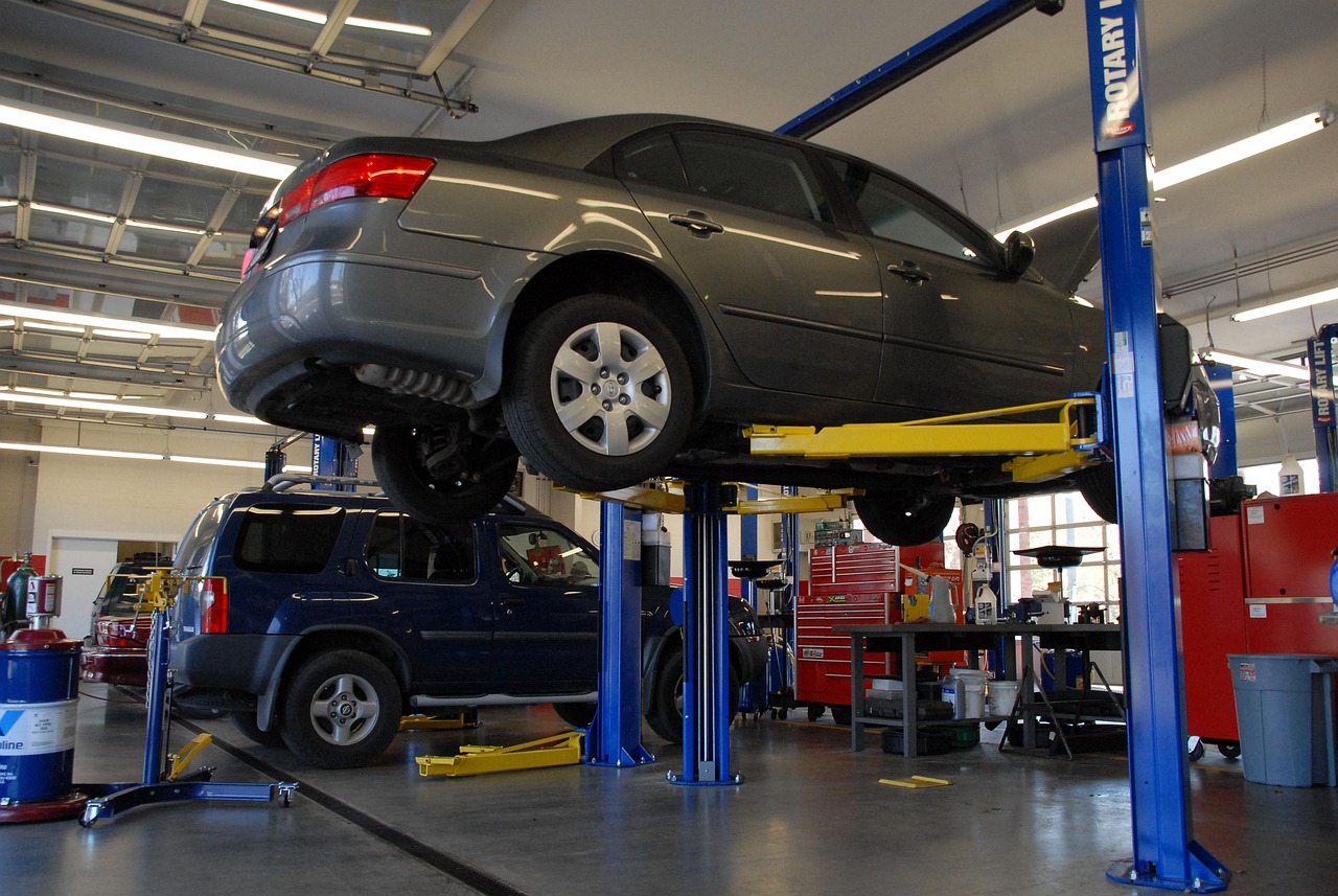 Automotive technician performing multi point inspection in service bay