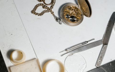 Watchmaker working on a mechanical movement at a workbench