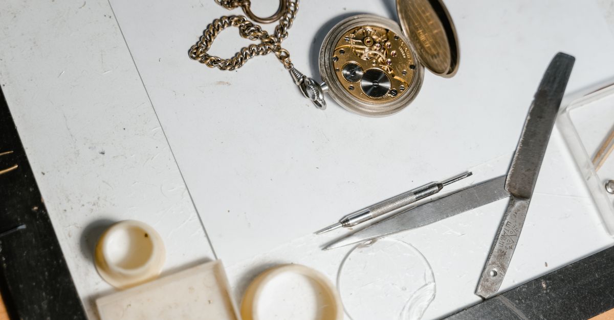 Watchmaker working on a mechanical movement at a workbench