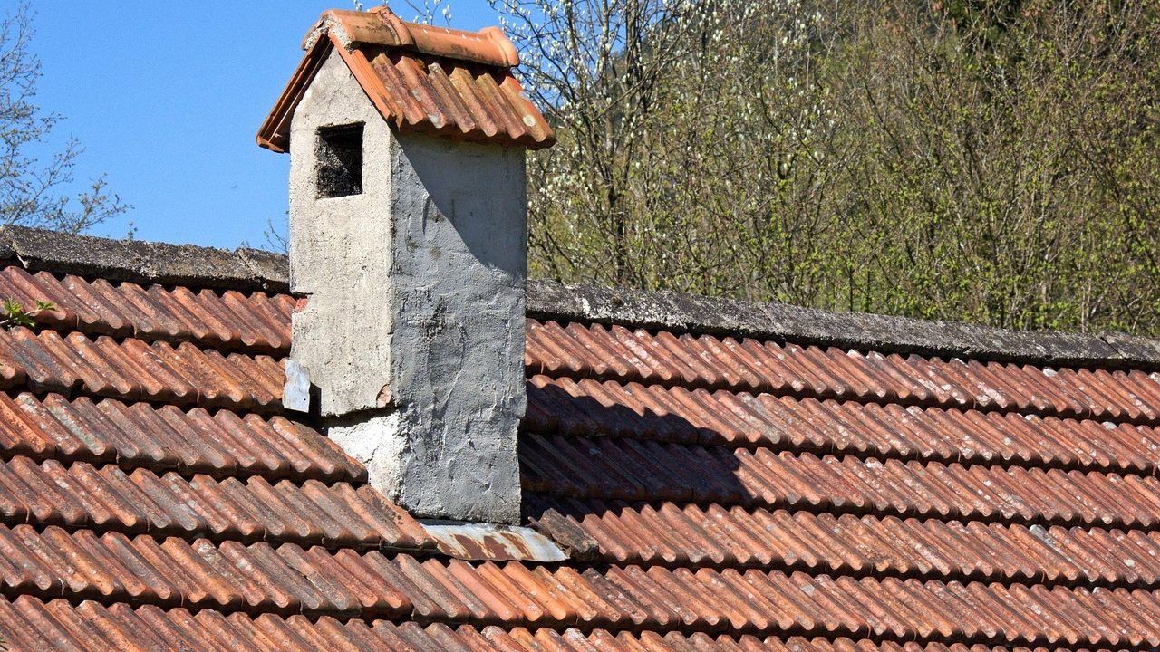 Close-up of a brick chimney on an asphalt shingle roof with custom copper counter-flashing.