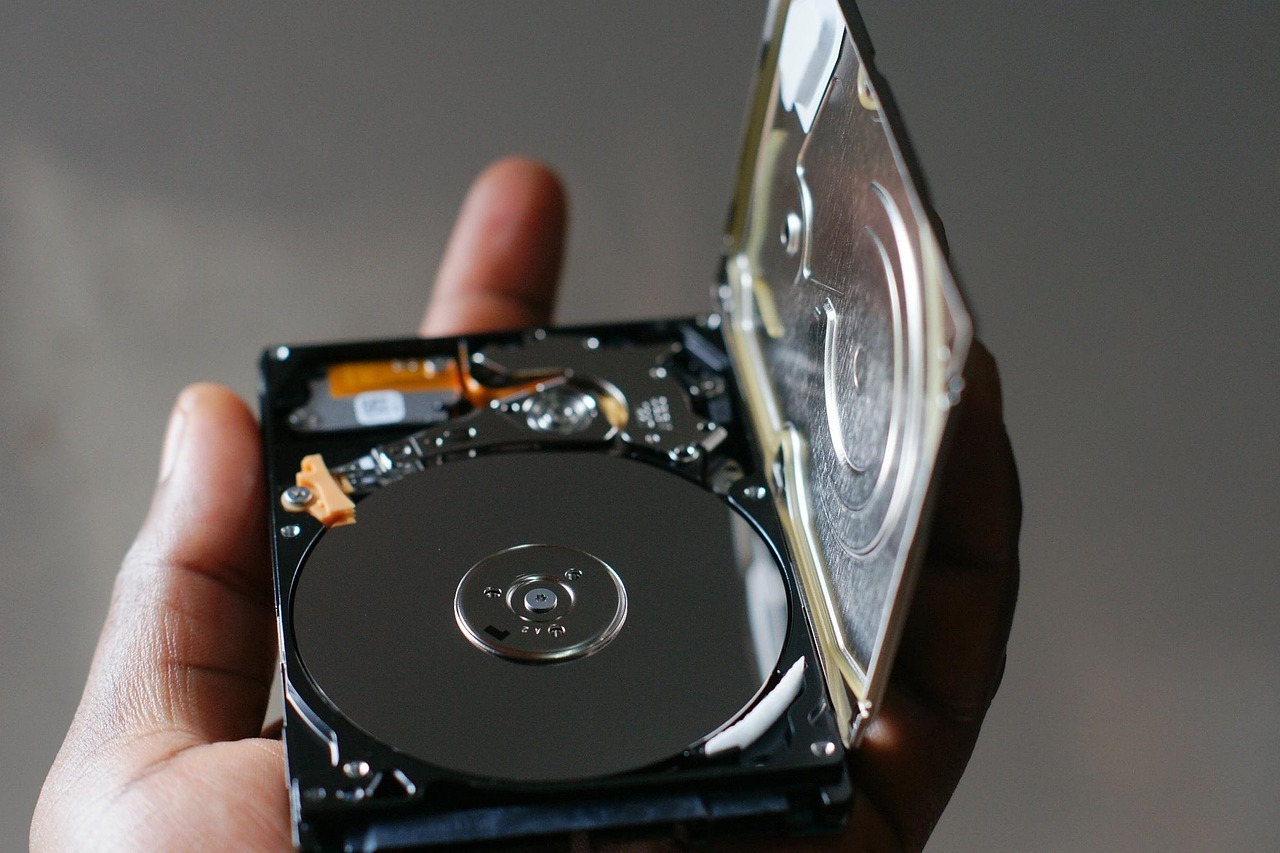 Close-up of an external hard drive plugged into a laptop during a backup process.