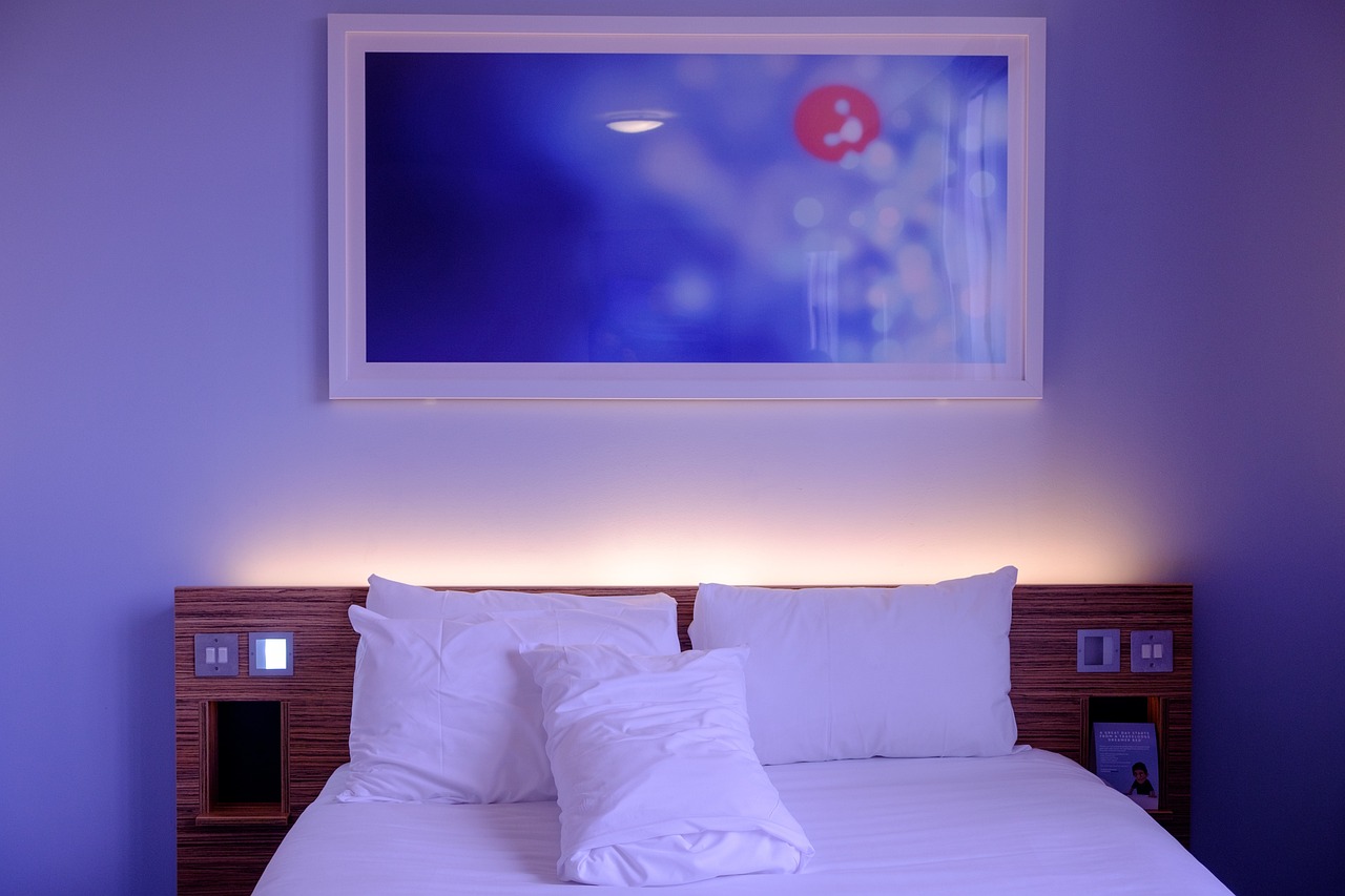 A modern, bright college dormitory room with a single desk and comfortable bed.