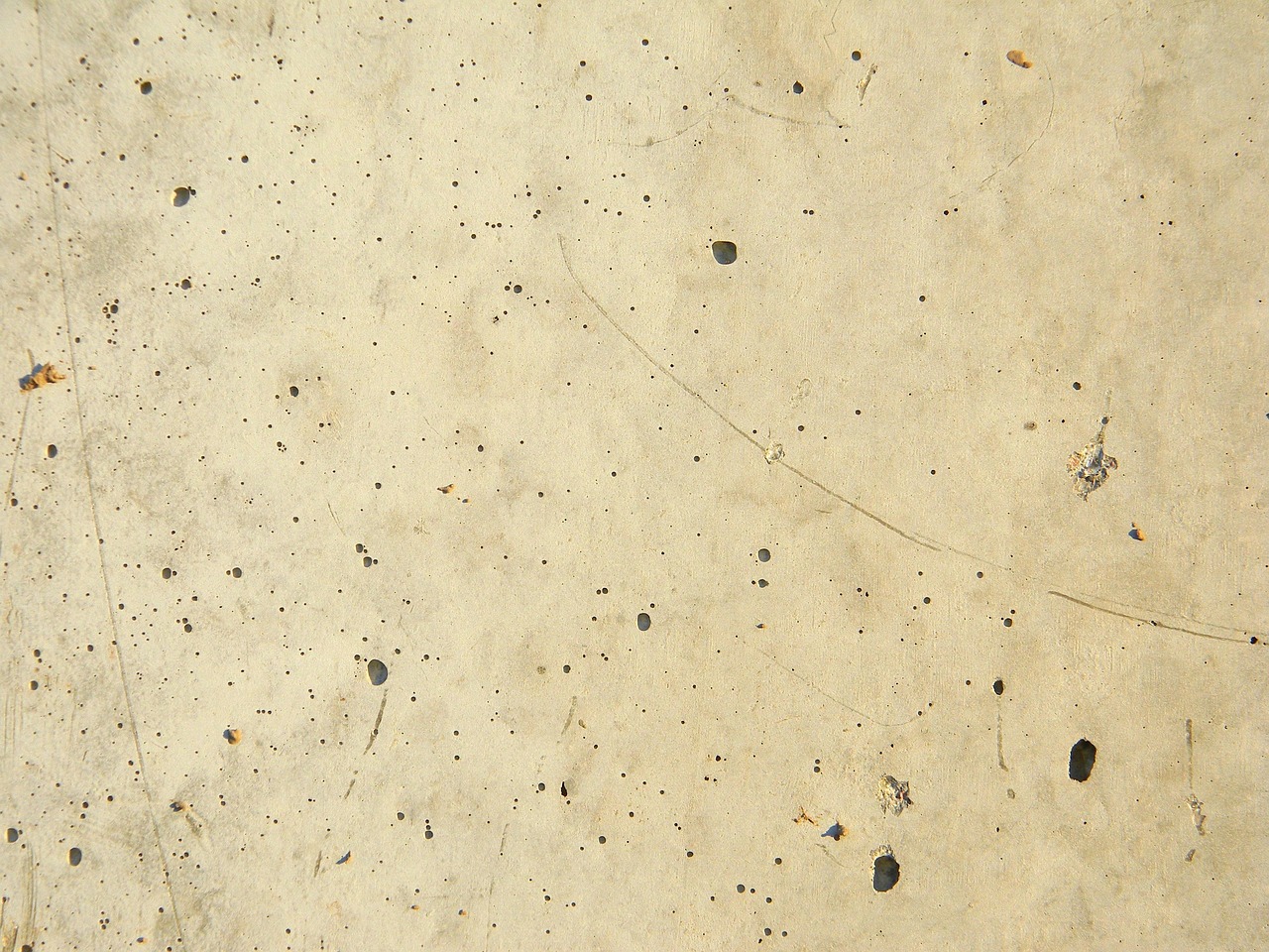A contractor drilling and pumping polyurethane foam under a sunken concrete slab.