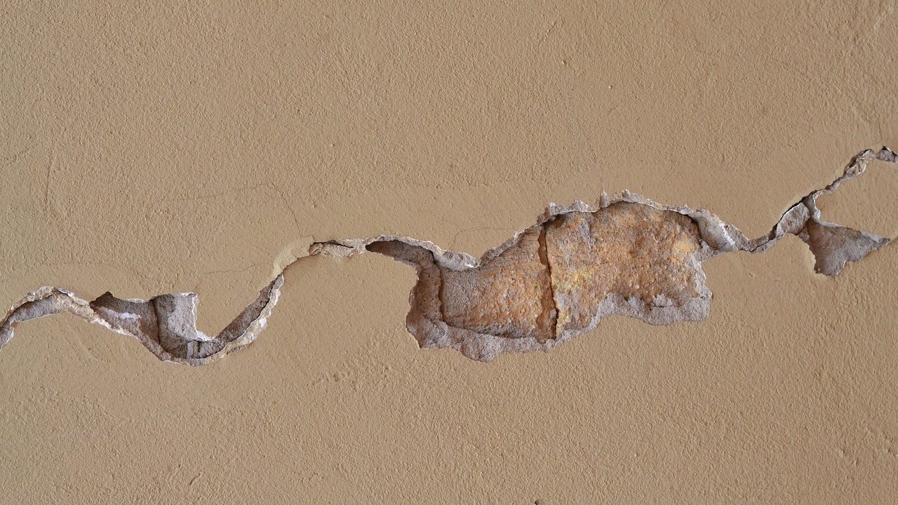 A cracked and sunken concrete patio slab outside a residential home.