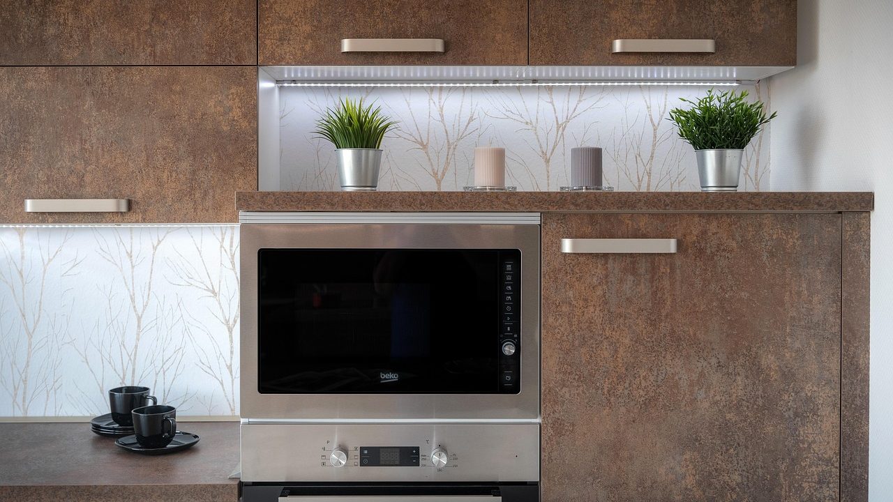 A sleek convection microwave installed above a kitchen range in a modern home kitchen.