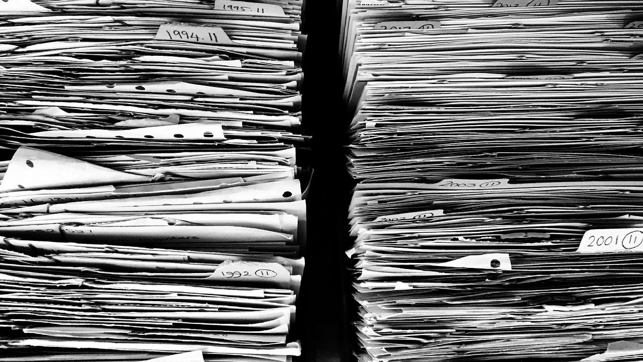 Severance documents and equity agreement paperwork on a desk in a corporate office setting.