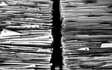 Severance documents and equity agreement paperwork on a desk in a corporate office setting.