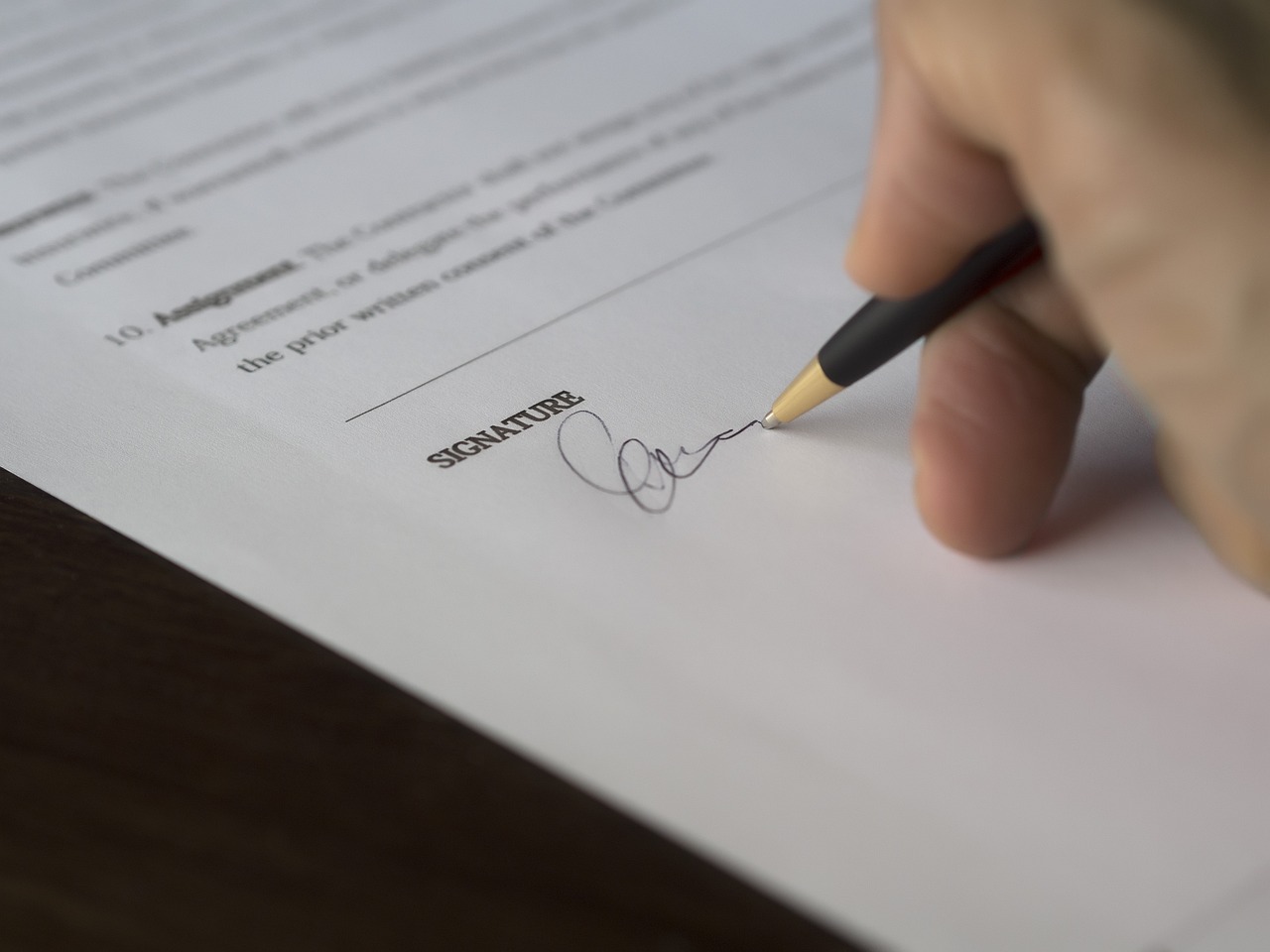 Close-up of equity grant contract paperwork being carefully reviewed with a pen.