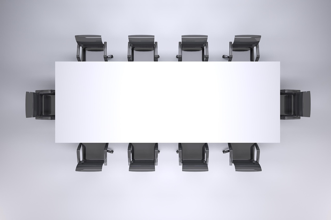 An empty corporate board meeting room with notebooks and documents on the table.