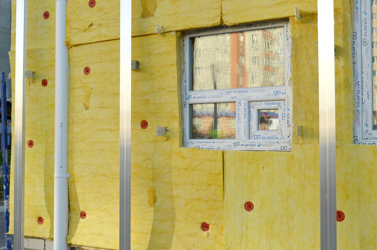 Rigid foam insulation board fitted inside a foundation vent opening with foam sealant applied around the edges.