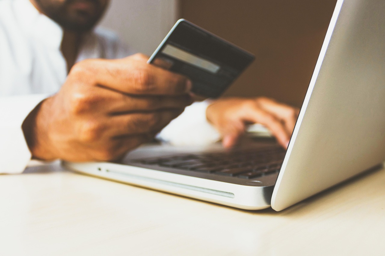A shopper organizing purchase documentation and printed credit card statements for a benefit claim.