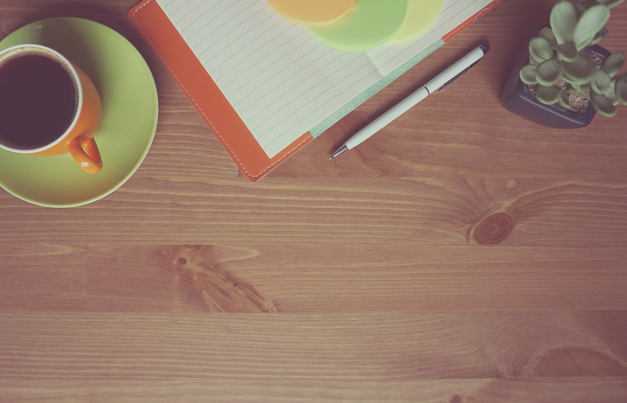 Professional working calmly at a table with a structured notebook checklist and laptop.