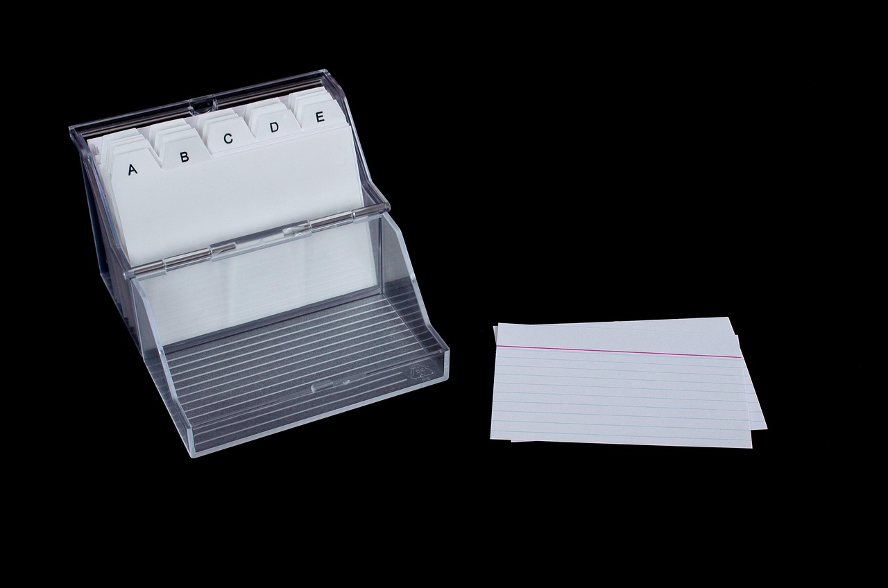 Hands organizing paper records and categorized index cards in a secure family binder.