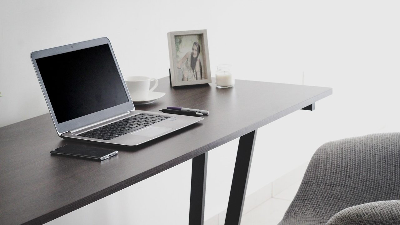 A home office desk with legal paperwork, a laptop, and a smartphone representing digital estate planning.