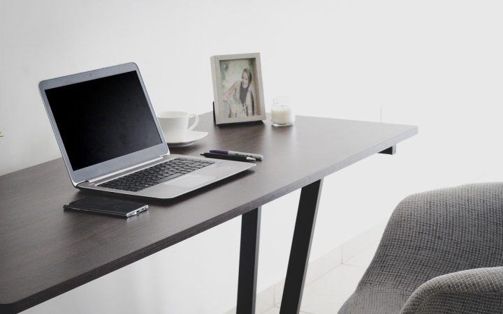 A home office desk with legal paperwork, a laptop, and a smartphone representing digital estate planning.