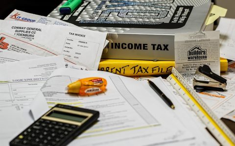 Official vehicle registration forms and financial hardship waiver paperwork neatly arranged on a desk