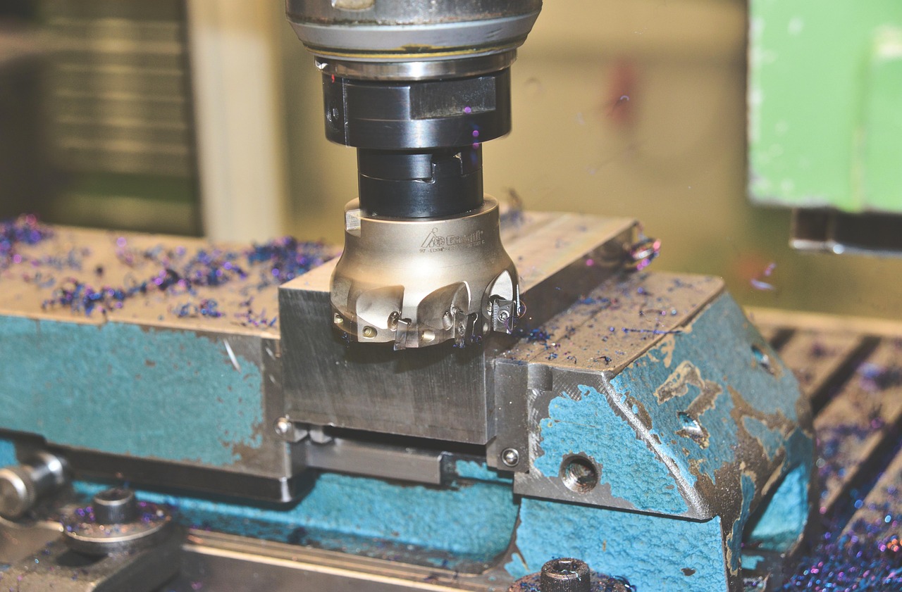 Close-up of an inline magnetic backdraft damper installed on a rigid metal dryer exhaust duct with foil tape seams.