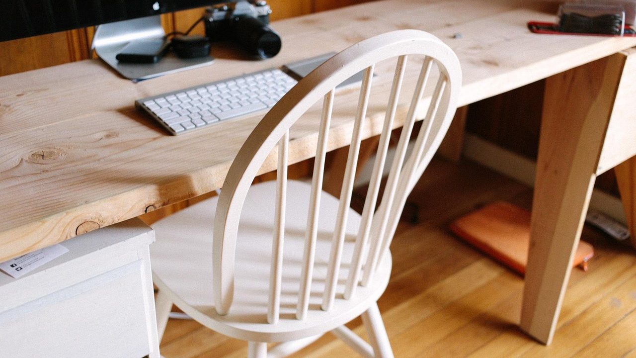 Clean compact home office setup featuring a dual monitor arm mounted to a shallow desk.