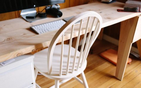 Clean compact home office setup featuring a dual monitor arm mounted to a shallow desk.