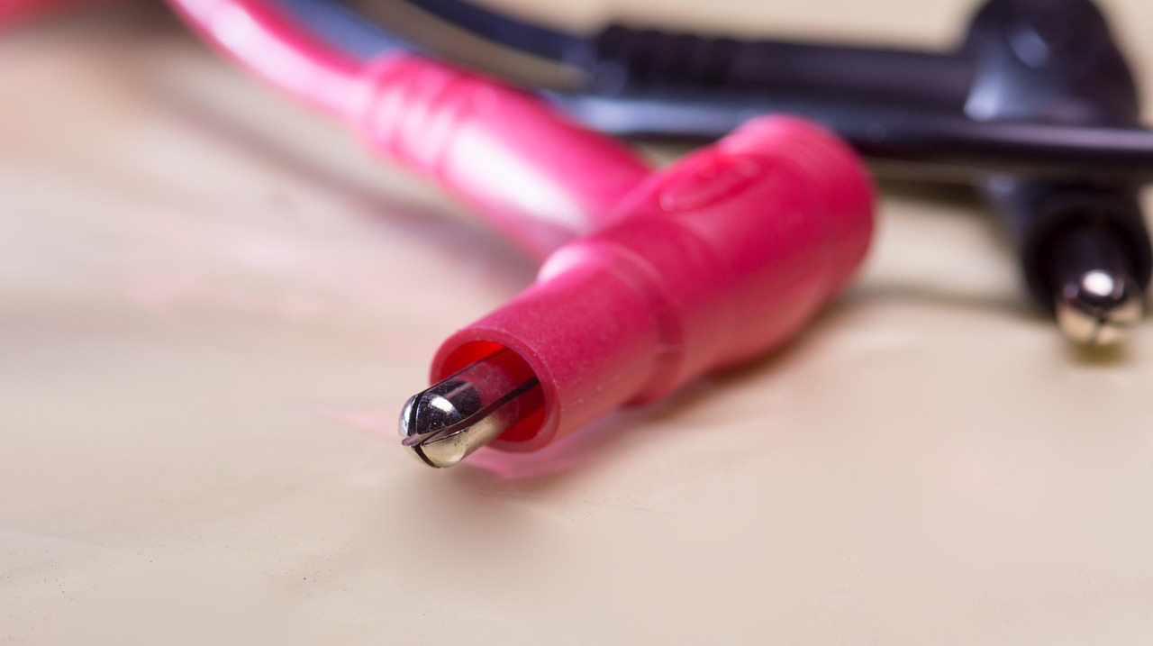 A technician using a digital multimeter to perform a continuity test on an unmounted electric oven bake element.
