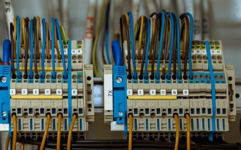 Electrician examining residential circuit breaker panel during a home inspection.