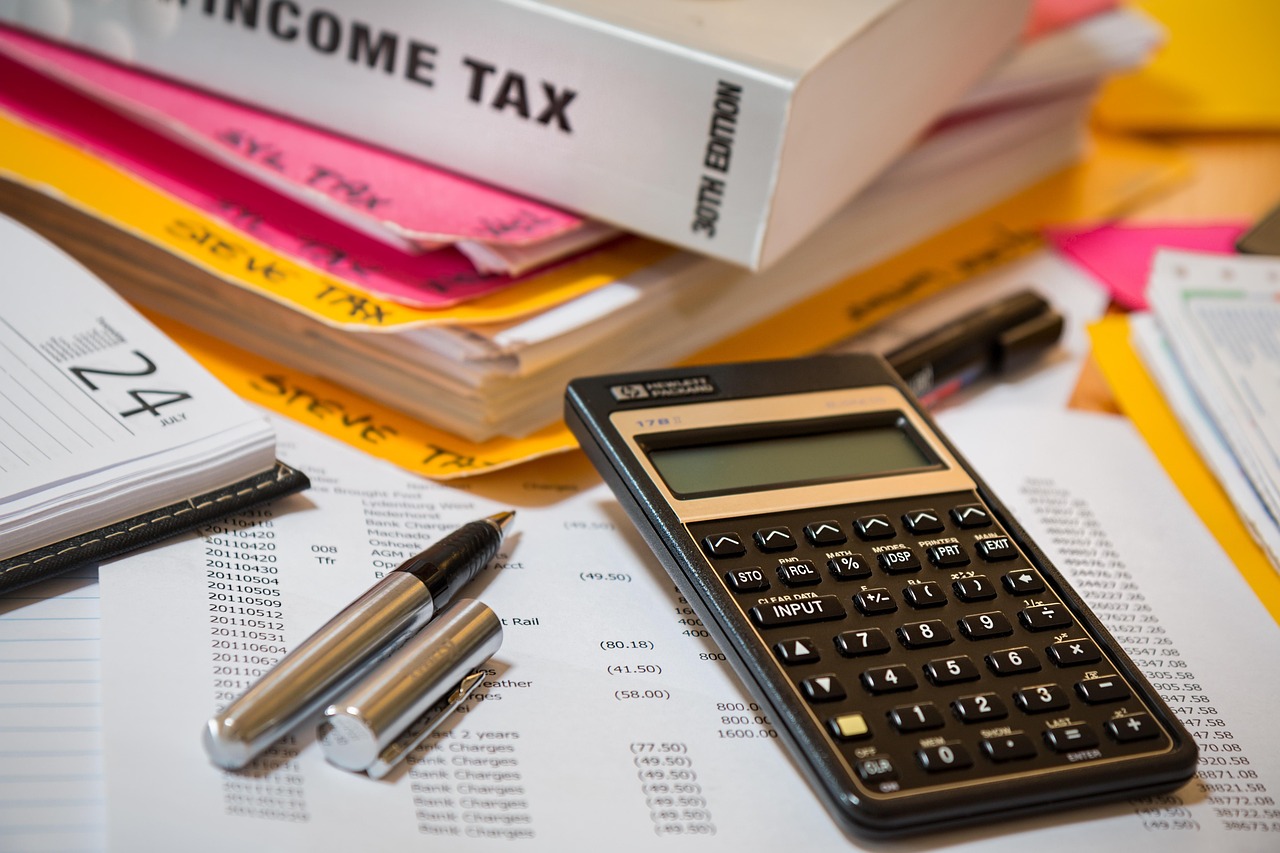 Payroll financial statement and tax calculator on a office desk.