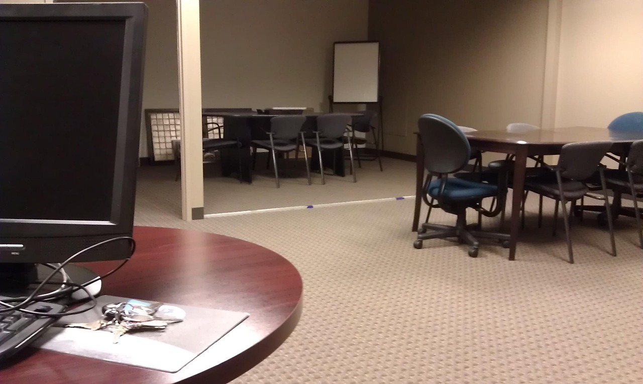 A corporate professional calculating financial repayment obligations on a laptop in a modern conference room.