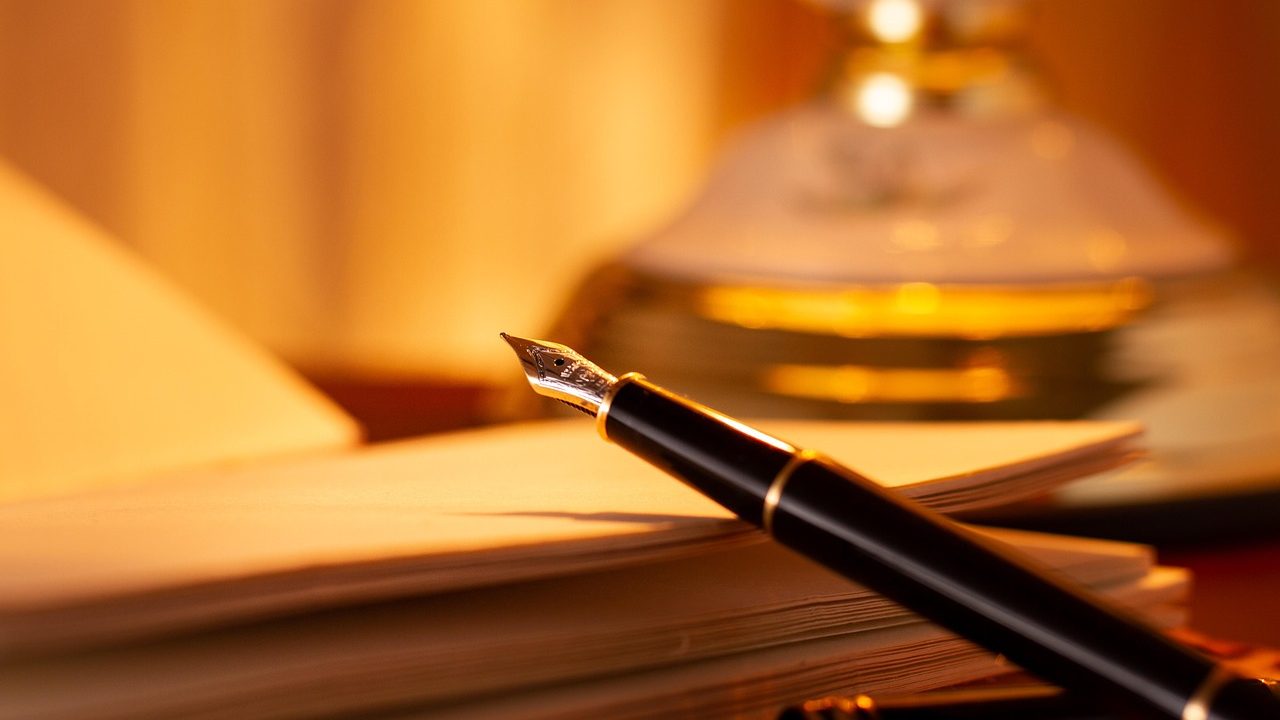 An employment agreement laying on a mahogany desk beside a fountain pen in a corporate office setting.