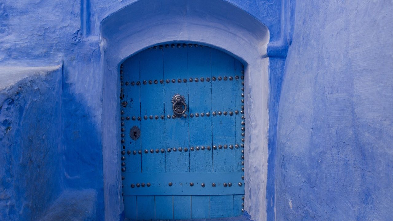 Carpenter leveling a new exterior door frame during home renovation.